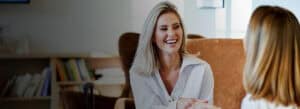 A friendly healthcare professional discusses wellness goals with a client in a comfortable clinic se.