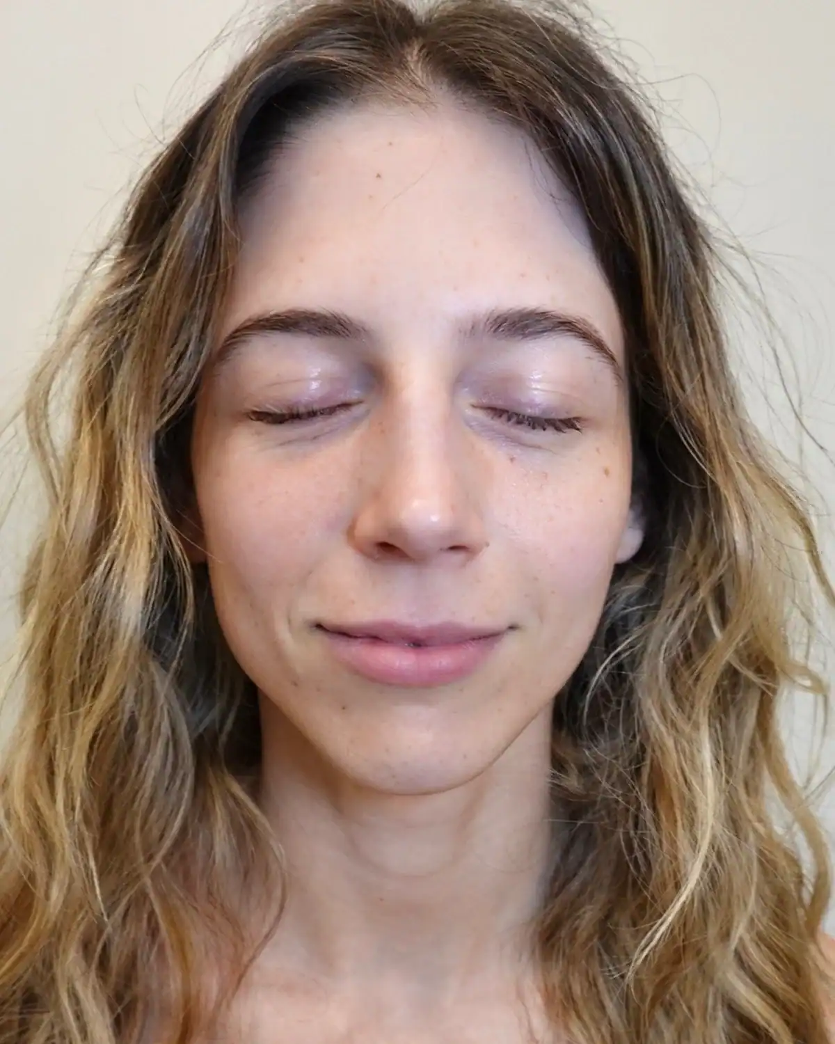 Close-up of a woman with relaxed expression and closed eyes.