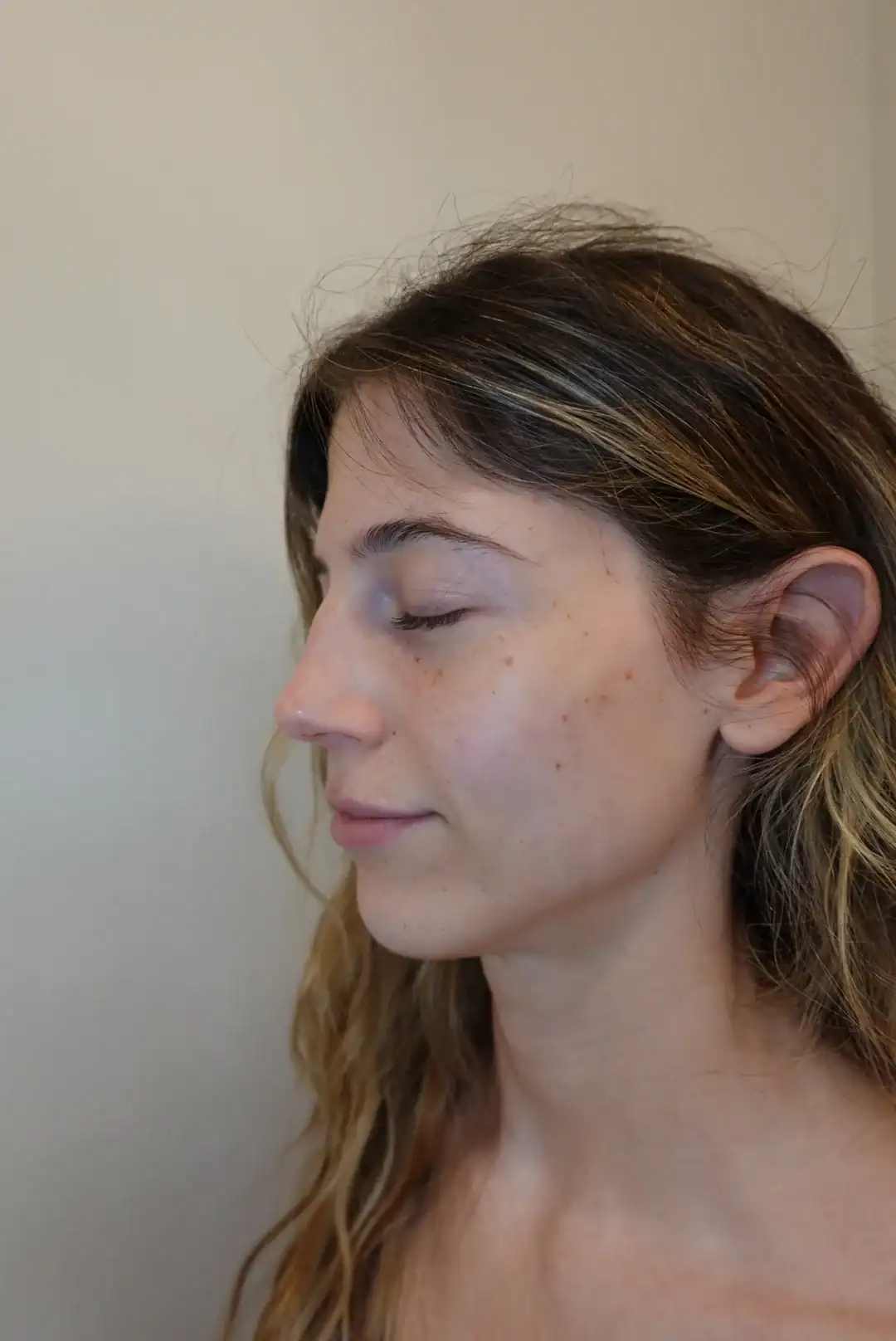 Close-up of a woman with clear skin and natural makeup in a wellness clinic.