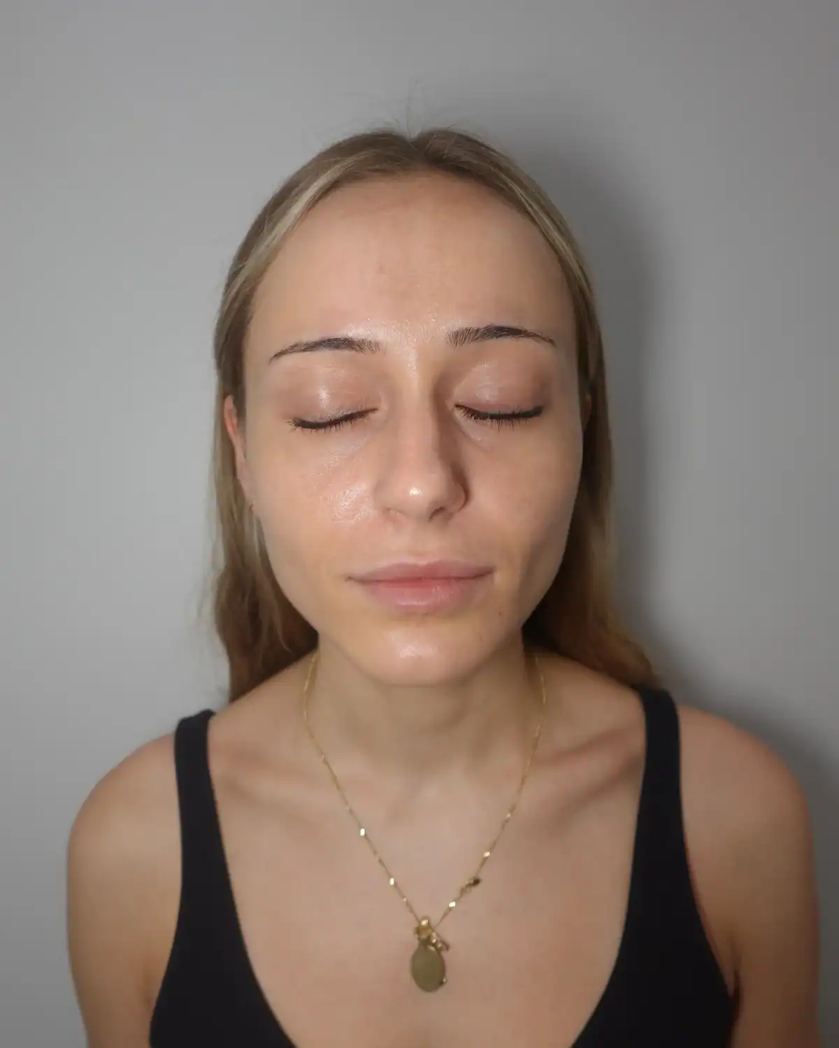 Close-up of a woman with clear, smooth skin and closed eyes.